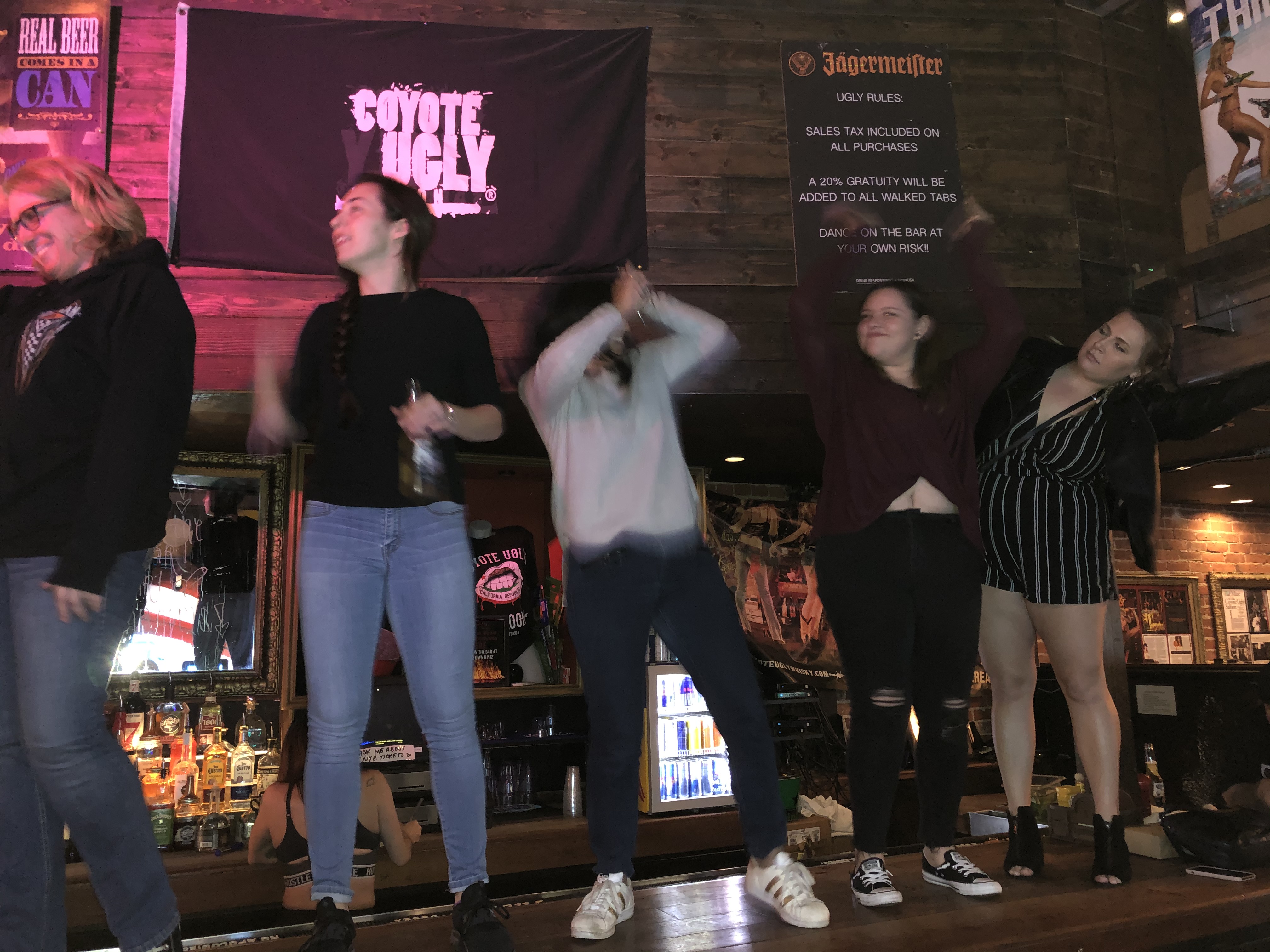 Dancing beneath a Coyote Ugly sign