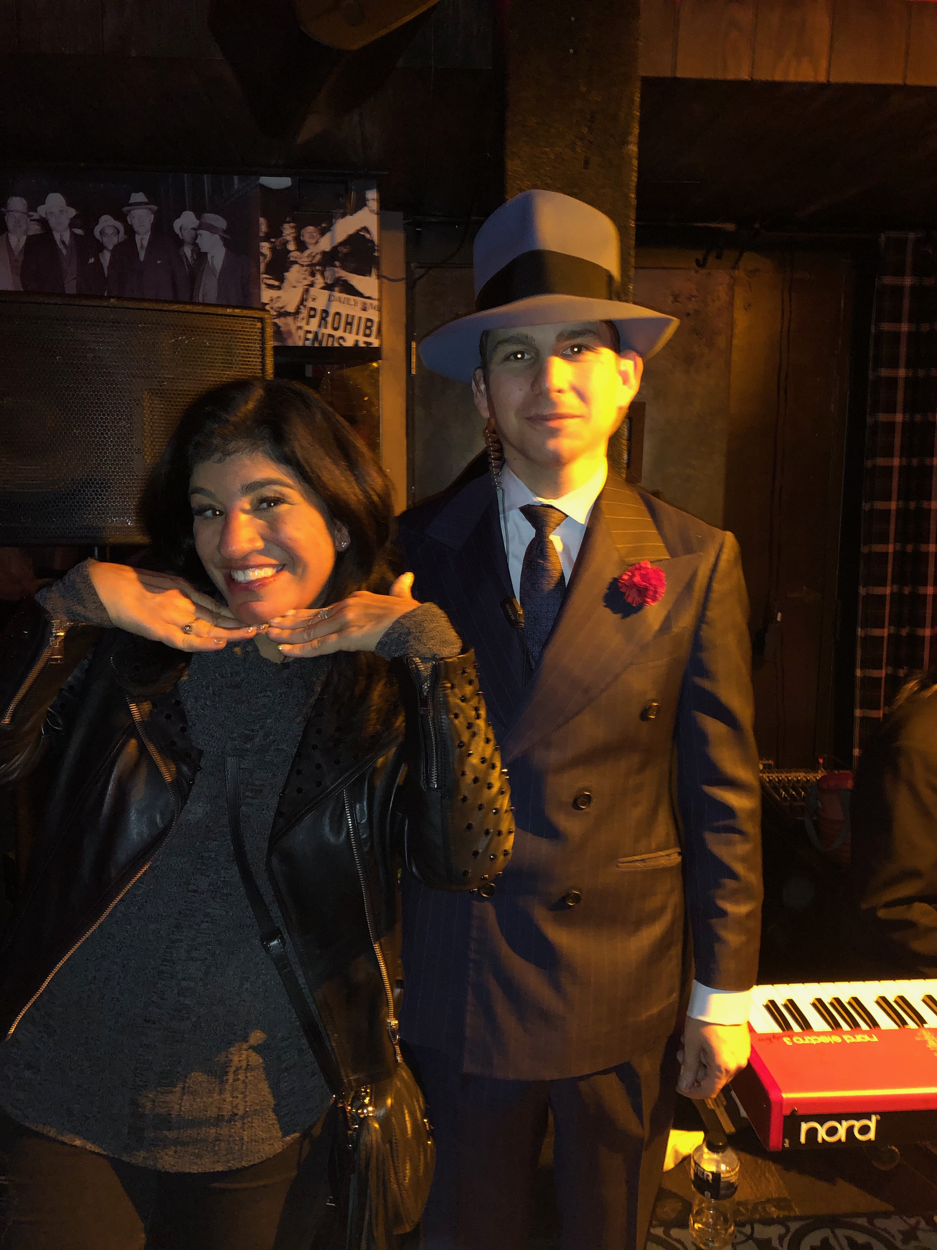 Kandi posing playfully beside a man in a vintage suit
